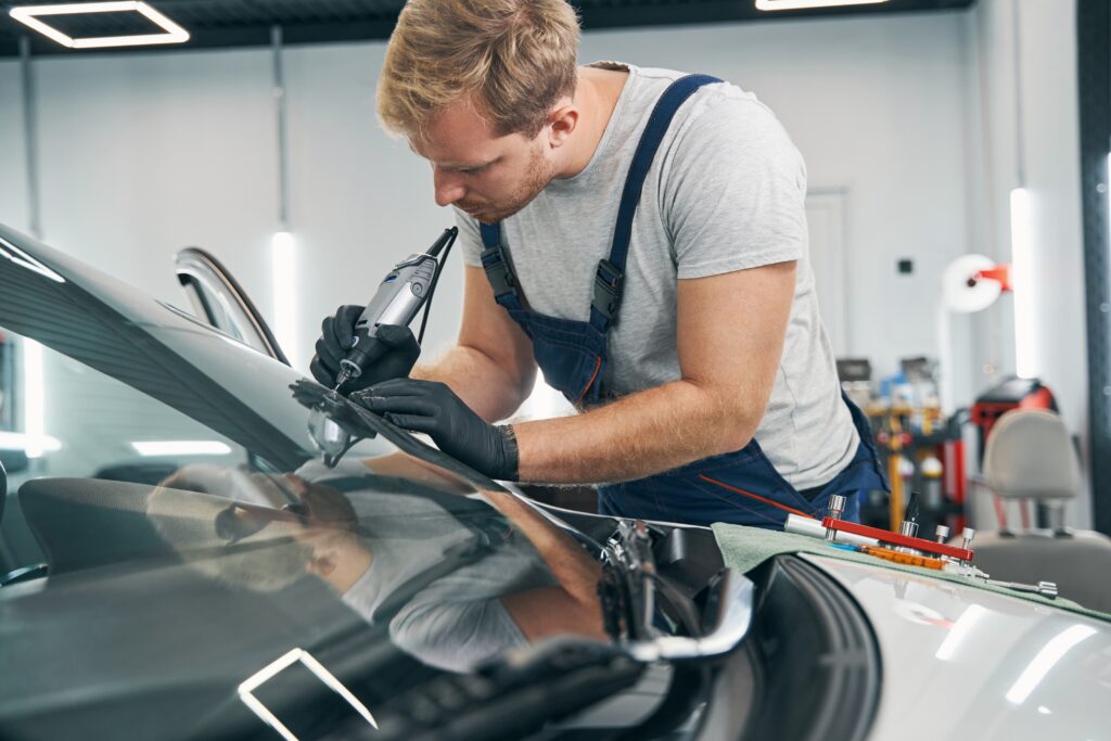 Technician inspecting and repairing a vehicle power window system.